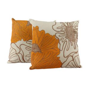 Almofada bordada com flores em tons de laranja queimado e bege. Um toque artesanal e vibrante para sua decoração.